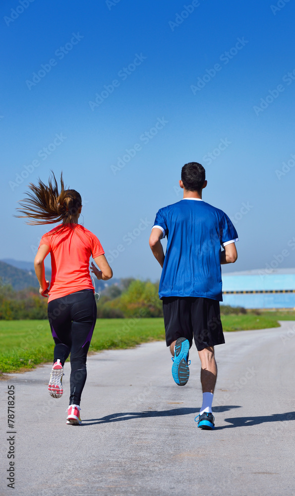 Young couple jogging in park at morning. Health and fitness. Young couple jogging in park at morning. Health and fitness.