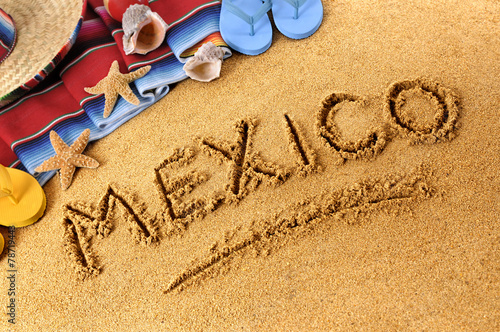 Mexico beach writing word written in sand on a mexican beach with sombrero and accessories photo