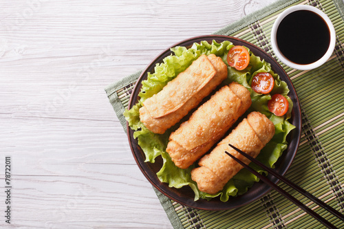 fried spring rolls on a plate with salad, horizontal top view