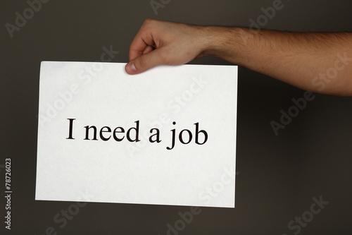 Sheet of paper with inscription I need a job in male hand