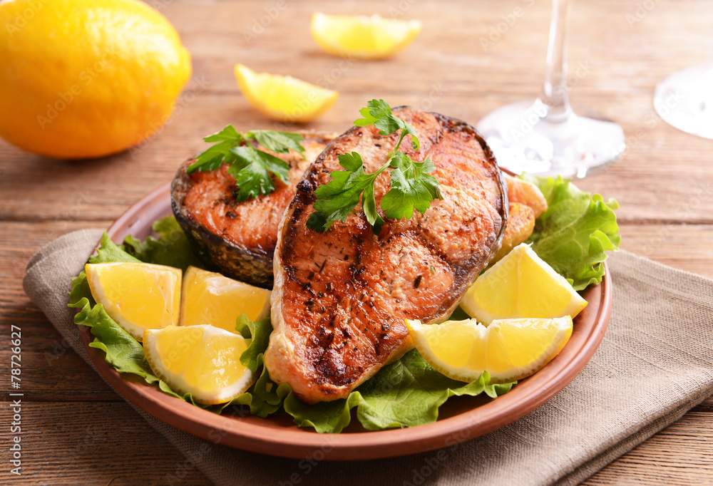 Tasty baked fish on plate on table close-up Tasty baked fish on plate on table close-up
