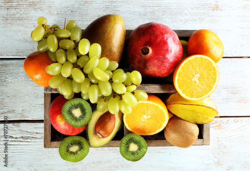 Assortment of fruits in box on wooden table