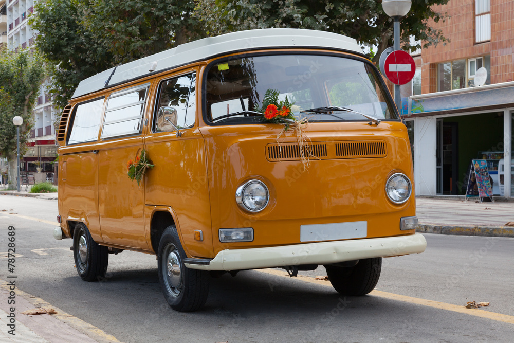 Orange minibus (minivan)  with white roof on the street.