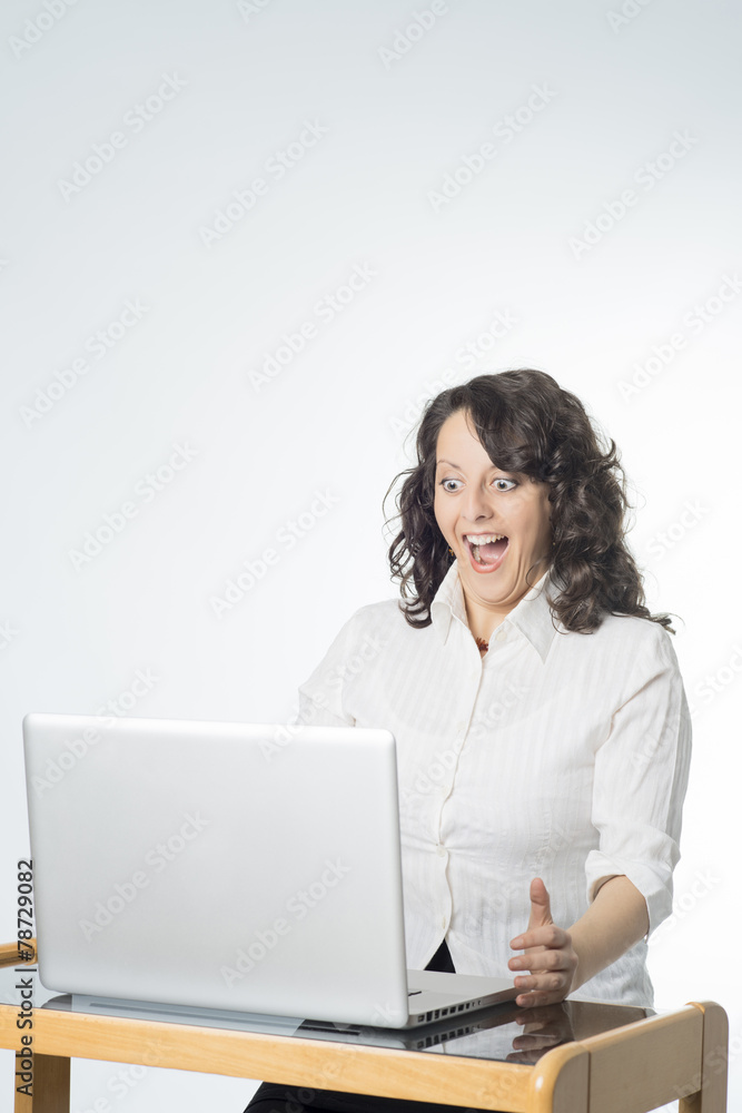 Young woman with surprise expression in front of laptop Young woman with surprise expression in front of laptop