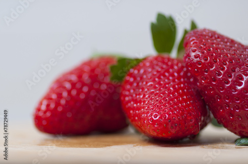 Strawberries on wooden table, with water drops