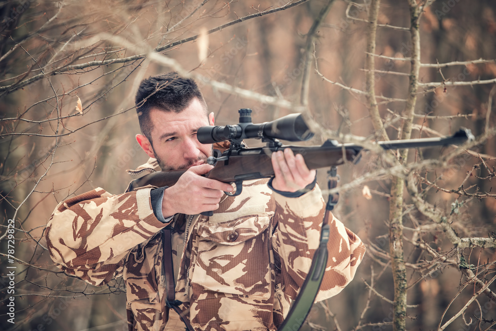 Fototapeta premium Man holding a sniper and shooting on an open season