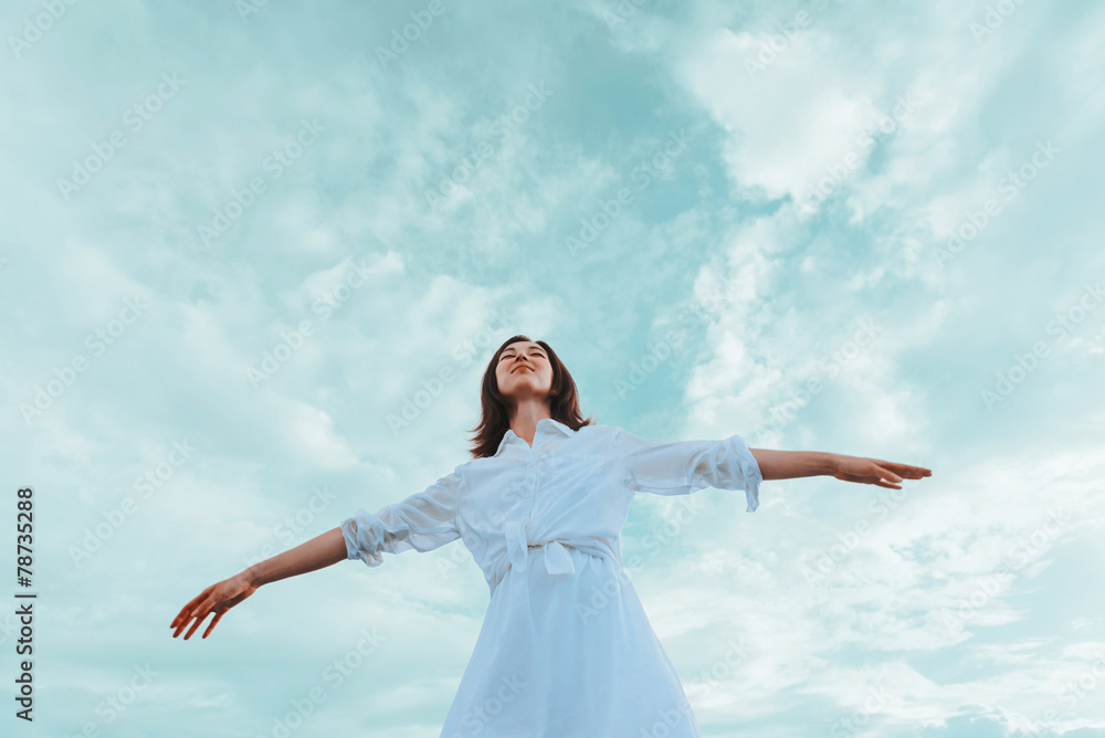 Young woman with raised arms enjoying a nice day Young woman with raised arms enjoying a nice day