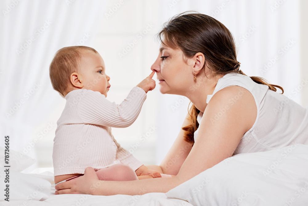 Woman and daughter playing in bed Woman and daughter playing in bed