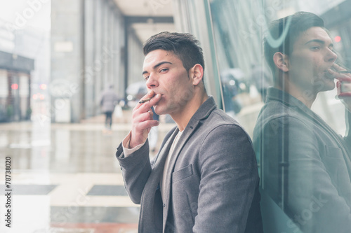 Young handsome man smoking a cigarette