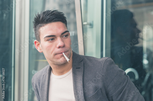 Young handsome man smoking a cigarette