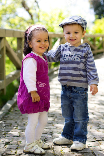 Two little adorable kids in the park, smiling at the camera photo