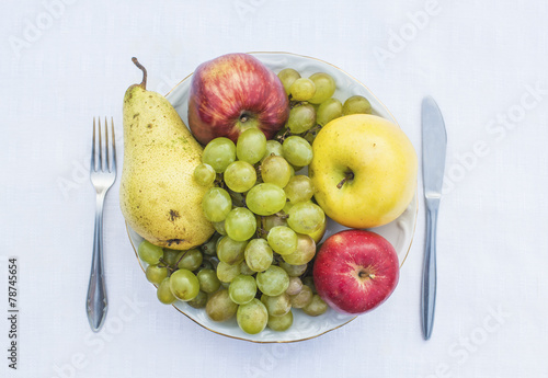 Plate full of natural fruits - grapes, apple, pear
