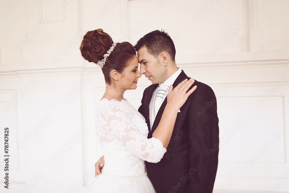 Bride and groom posing in a white palace room Bride and groom posing in a white palace room