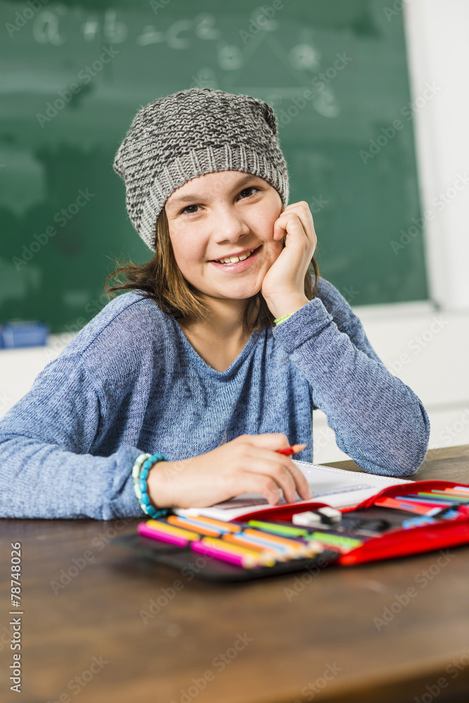 Lächelndes Mödchen sitz in Klassenzimmer Lächelndes Mödchen sitz in Klassenzimmer