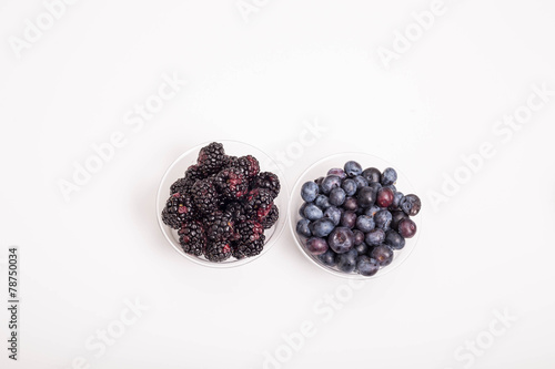 Blackberries and Blueberries in Cups on White with Copy Space