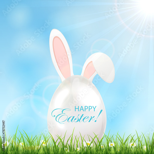 Easter egg with ears in a grass