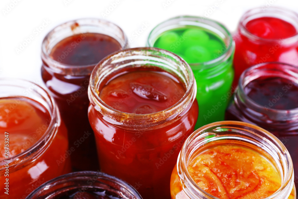Homemade jars of fruits jam on color table background Homemade jars of fruits jam on color table background