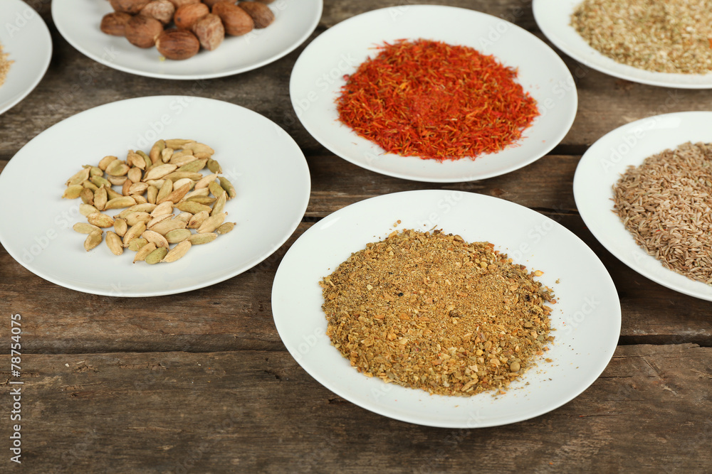 Different spices on plates, on old wooden table Different spices on plates, on old wooden table
