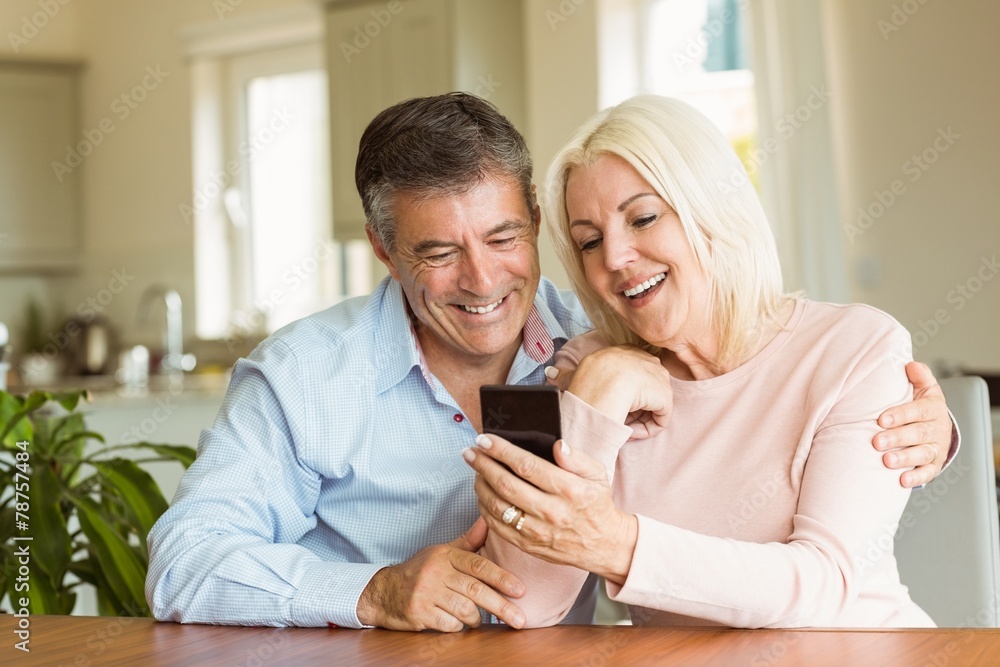 Happy mature couple looking at smartphone together Happy mature couple looking at smartphone together