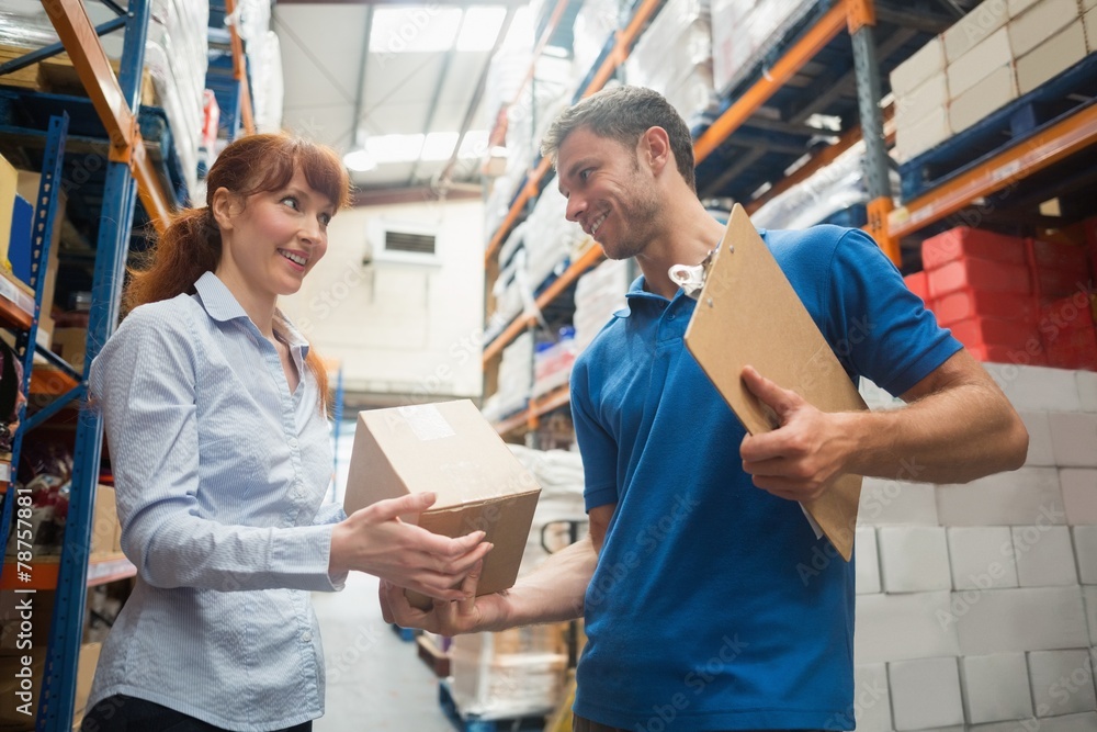 Obraz premium Delivery man passing parcel to warehouse manager
