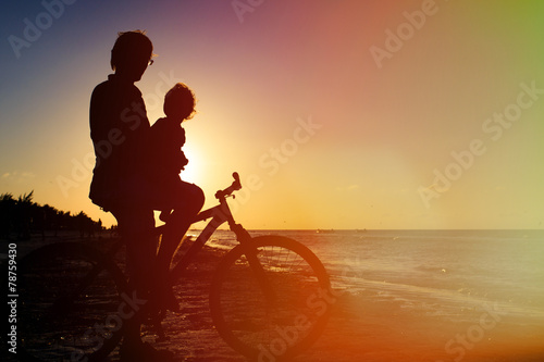 Silhouette of father and baby biking at sunset © nadezhda1906