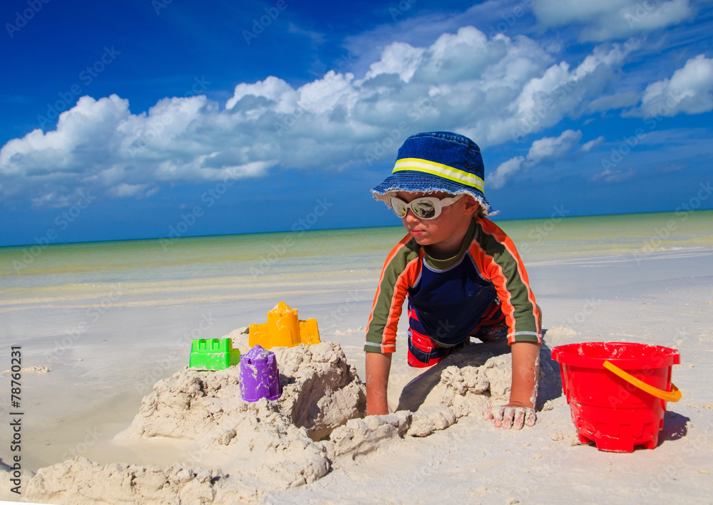 little boy digging sand on tropical beach little boy digging sand on tropical beach