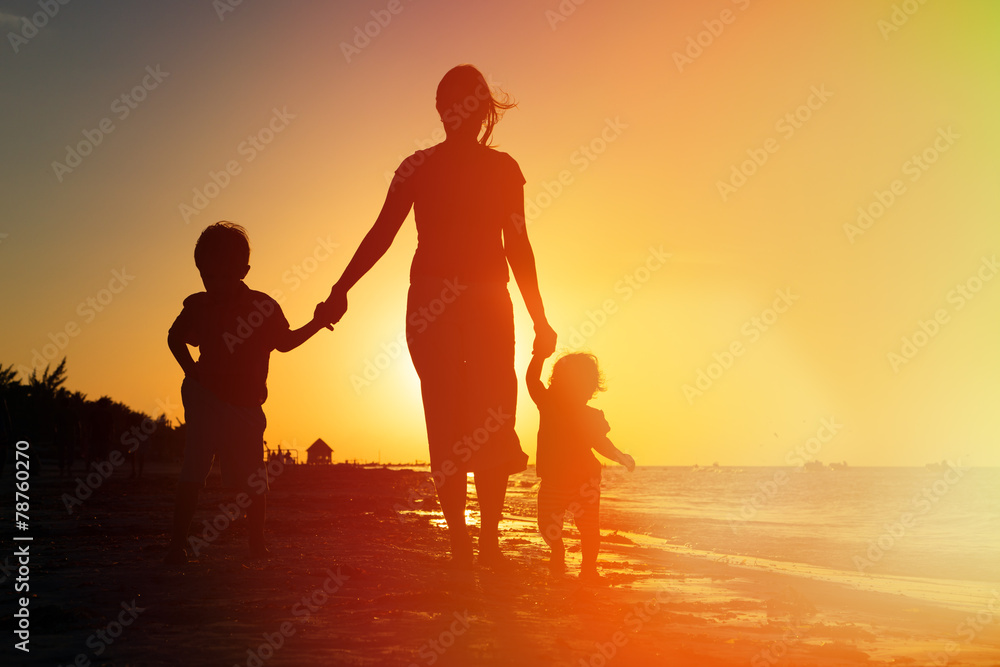 mother and two kids walking on at sunset