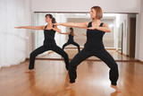 two women making a fitness exercises in synchrony