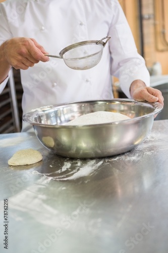 Baker working with sieve and bowl