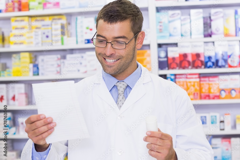 Happy pharmacist looking at prescription