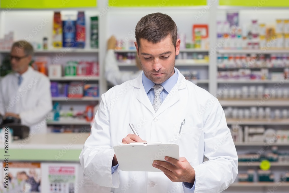 Pharmacist writing on clipboard