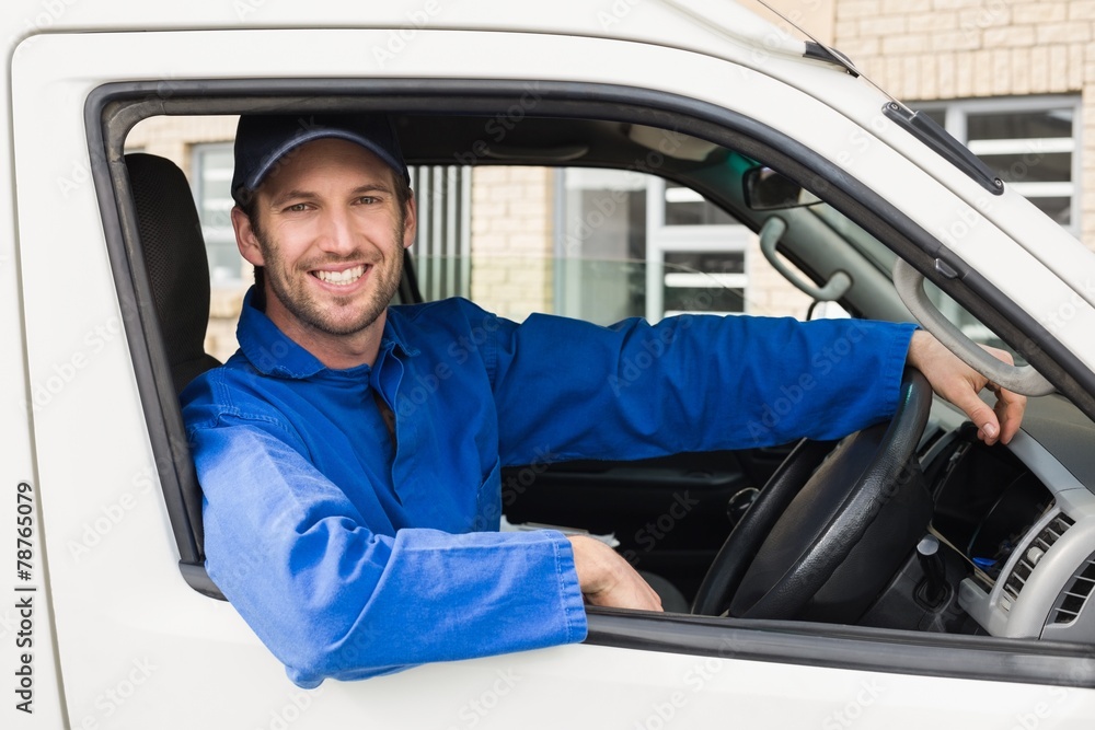 Delivery driver smiling at camera in his van Delivery driver smiling at camera in his van