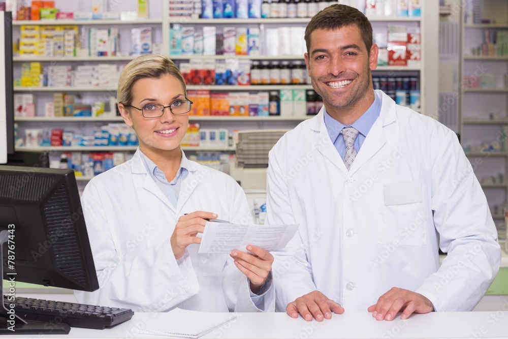 Team of pharmacists looking at paper Team of pharmacists looking at paper