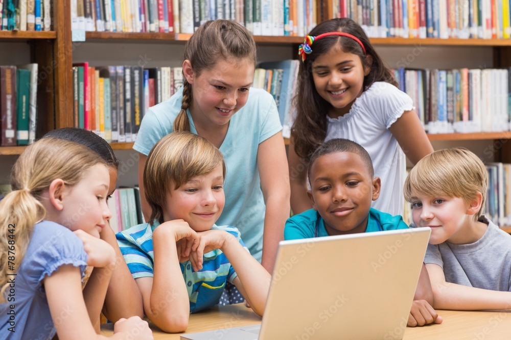 Cute pupils using tablet computer in library Cute pupils using tablet computer in library
