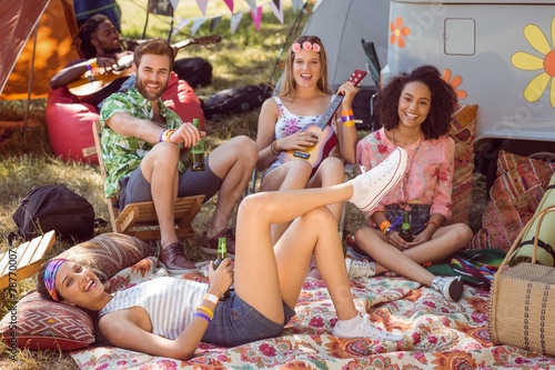 Happy hipsters relaxing on campsite