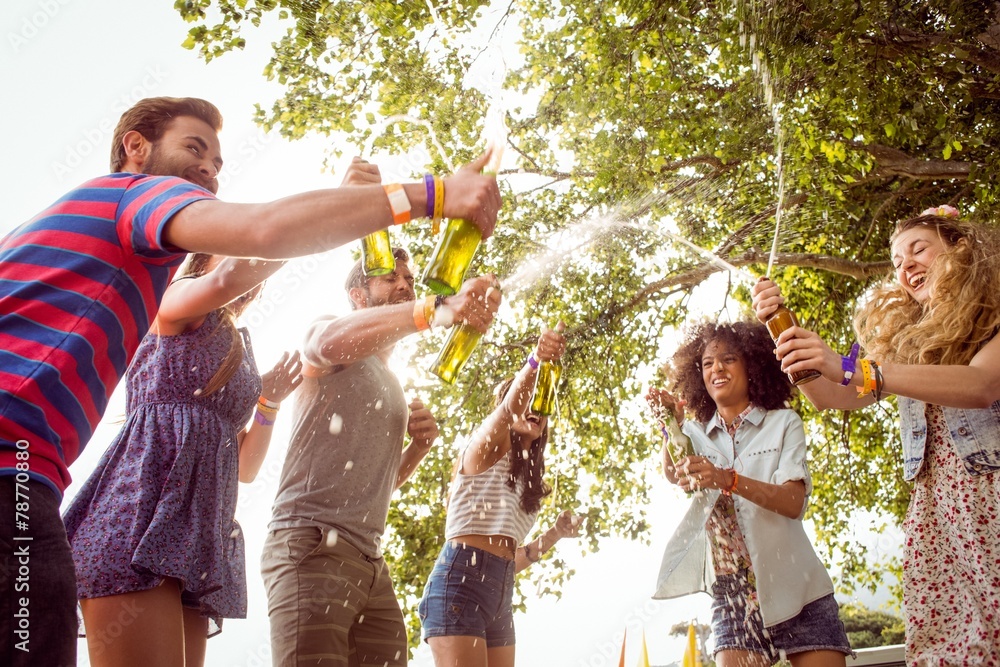 Fototapeta premium Happy hipsters spraying beer bottles