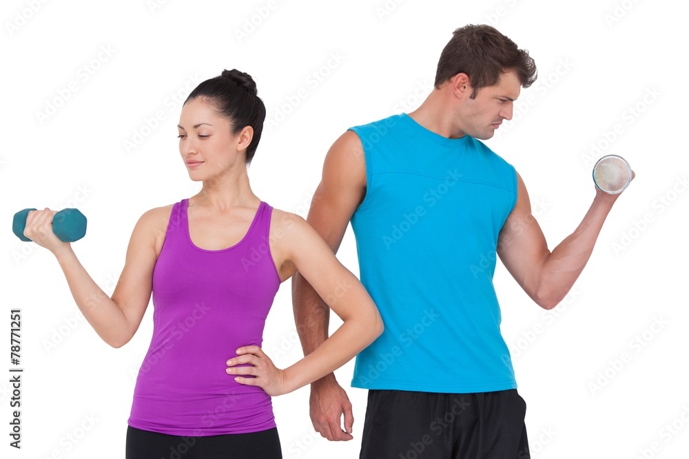 Fit man and woman lifting dumbbells