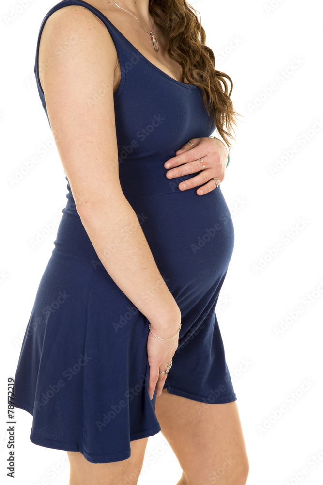 body of pregnant woman in blue dress holding belly body of pregnant woman in blue dress holding belly