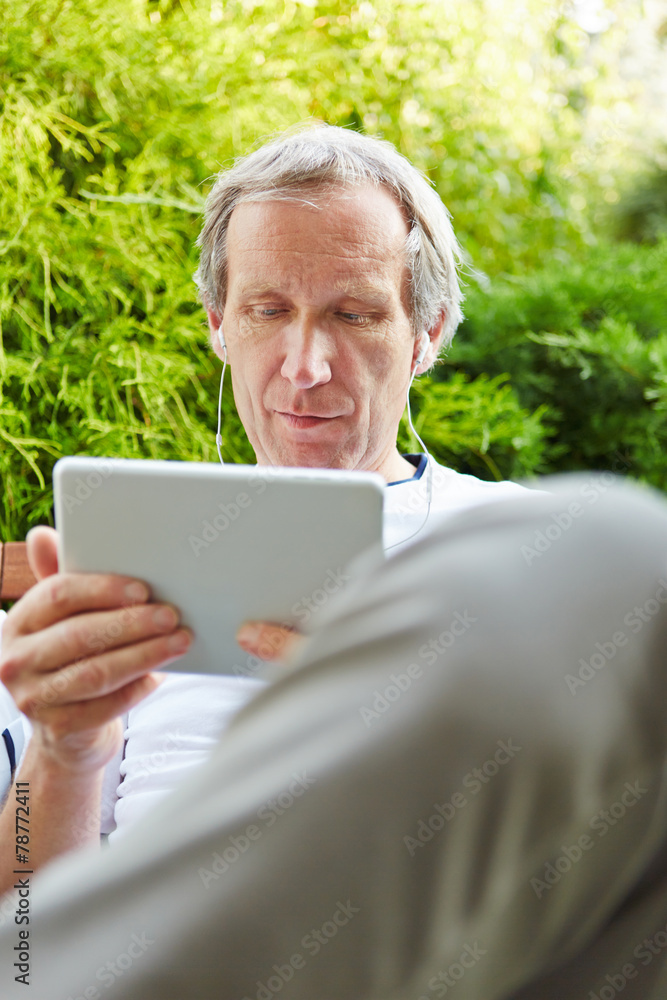 Alter Mann mit Tablet Computer und Kopfhörer Alter Mann mit Tablet Computer und Kopfhörer
