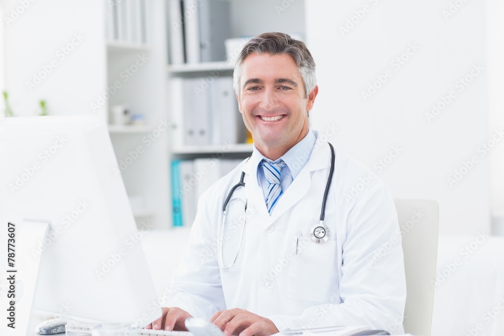 Confident doctor using computer in clinic Confident doctor using computer in clinic