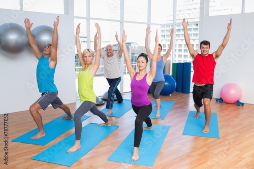 People with hands raised doing yoga