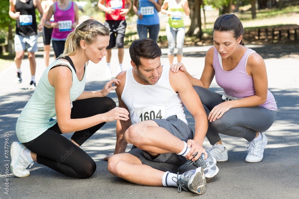 Man with injured ankle during race in park Man with injured ankle during race in park