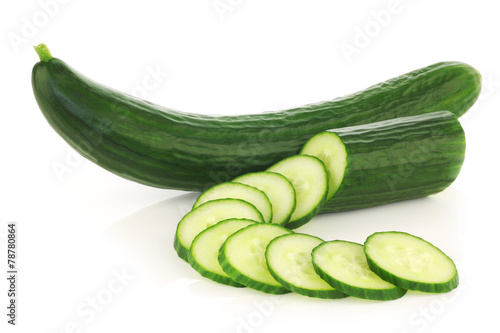 fresh cucumber and some cut slices on a white background