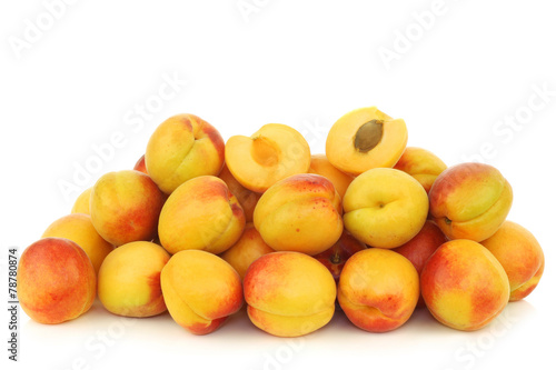 fresh colorful apricots and a cut one on a white background