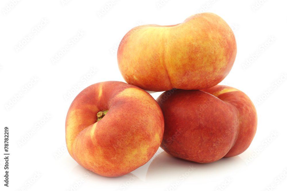 Fresh wild (flat) stacked nectarines on a white background Fresh wild (flat) stacked nectarines on a white background