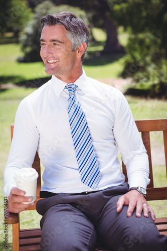 Businessman having coffee in the park