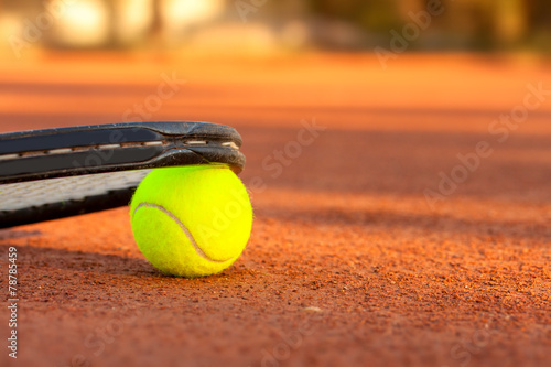 Tennis ball and racquet on a tennis clay court © Kavita