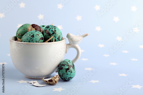 Bird colorful eggs in mug on bright background