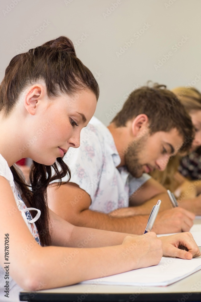 Students writing notes in classroom Students writing notes in classroom