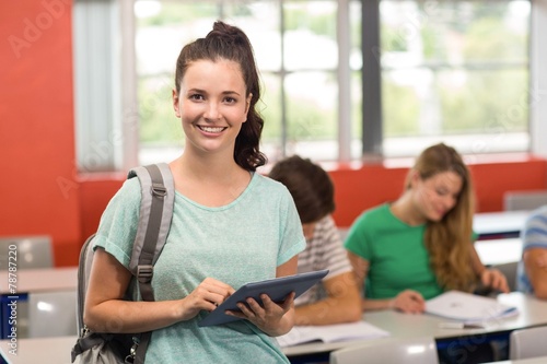 Female student using digital tablet in classroom